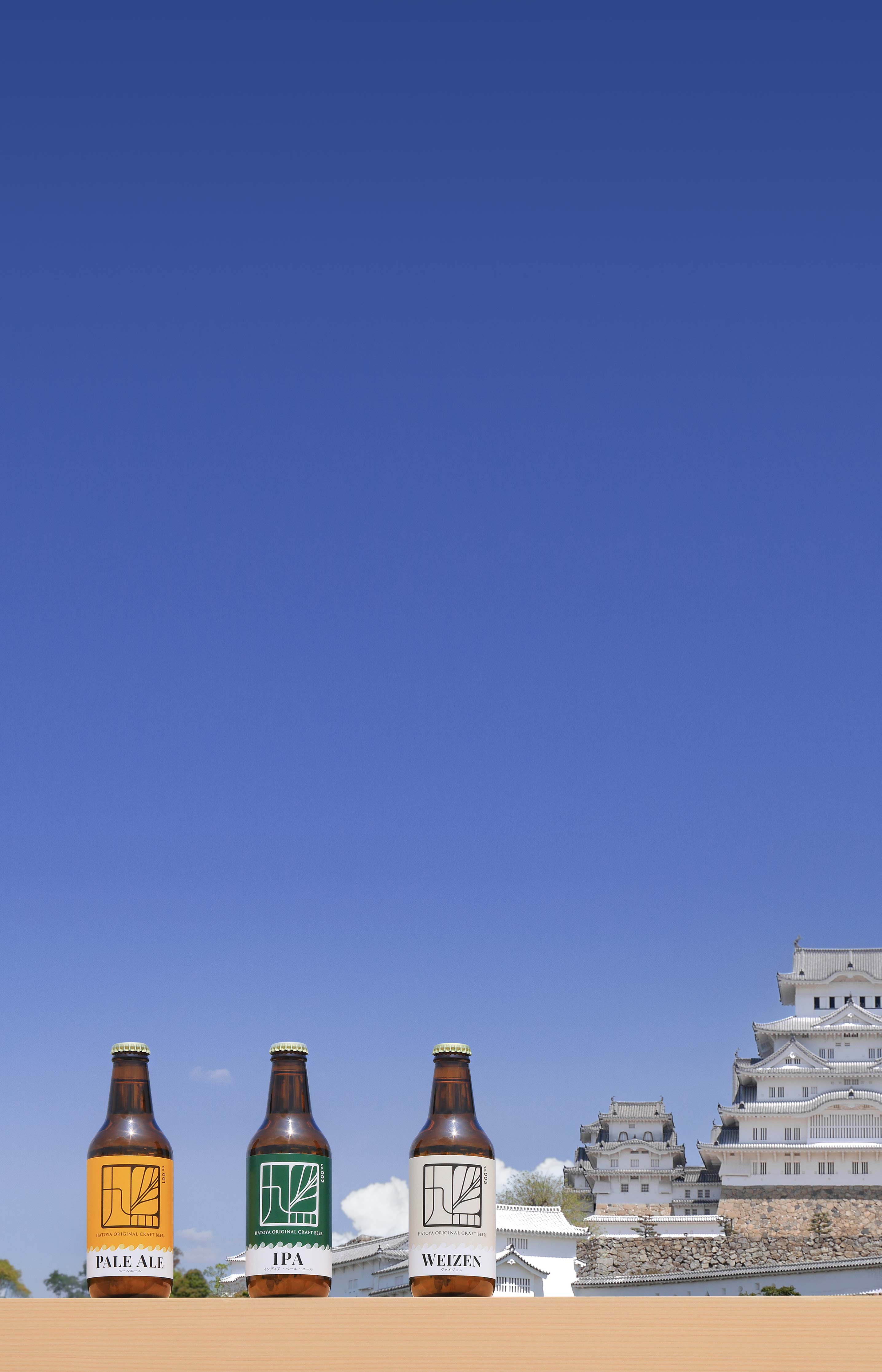 姫路城天守閣を背景に3種類のビールが並んでいる写真