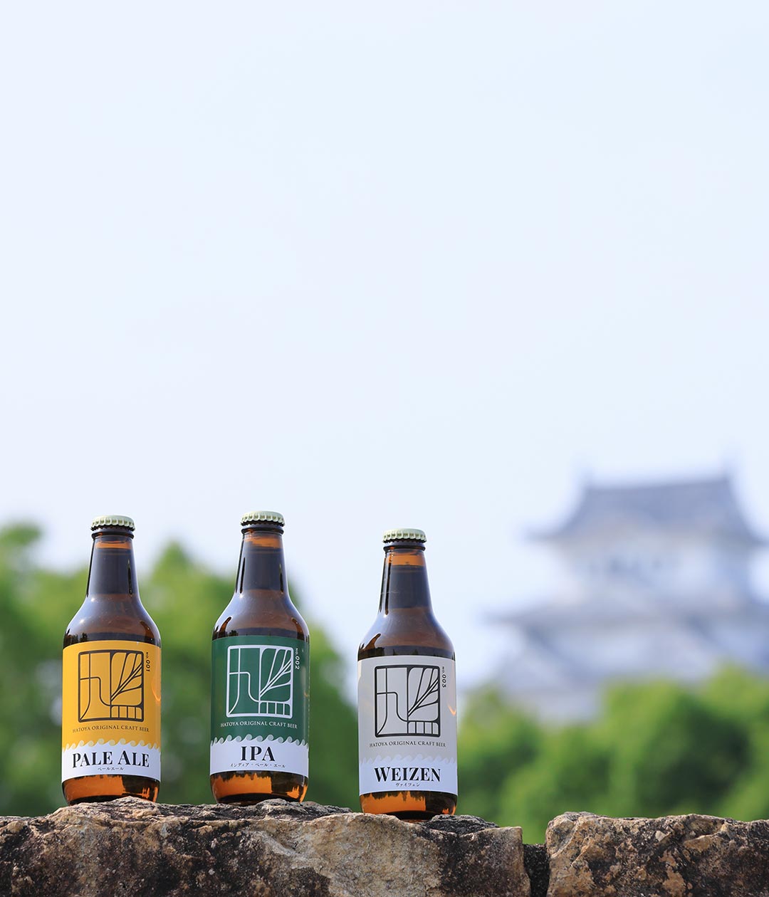 新緑を背景に3種類のビールが高台に並んでいる写真