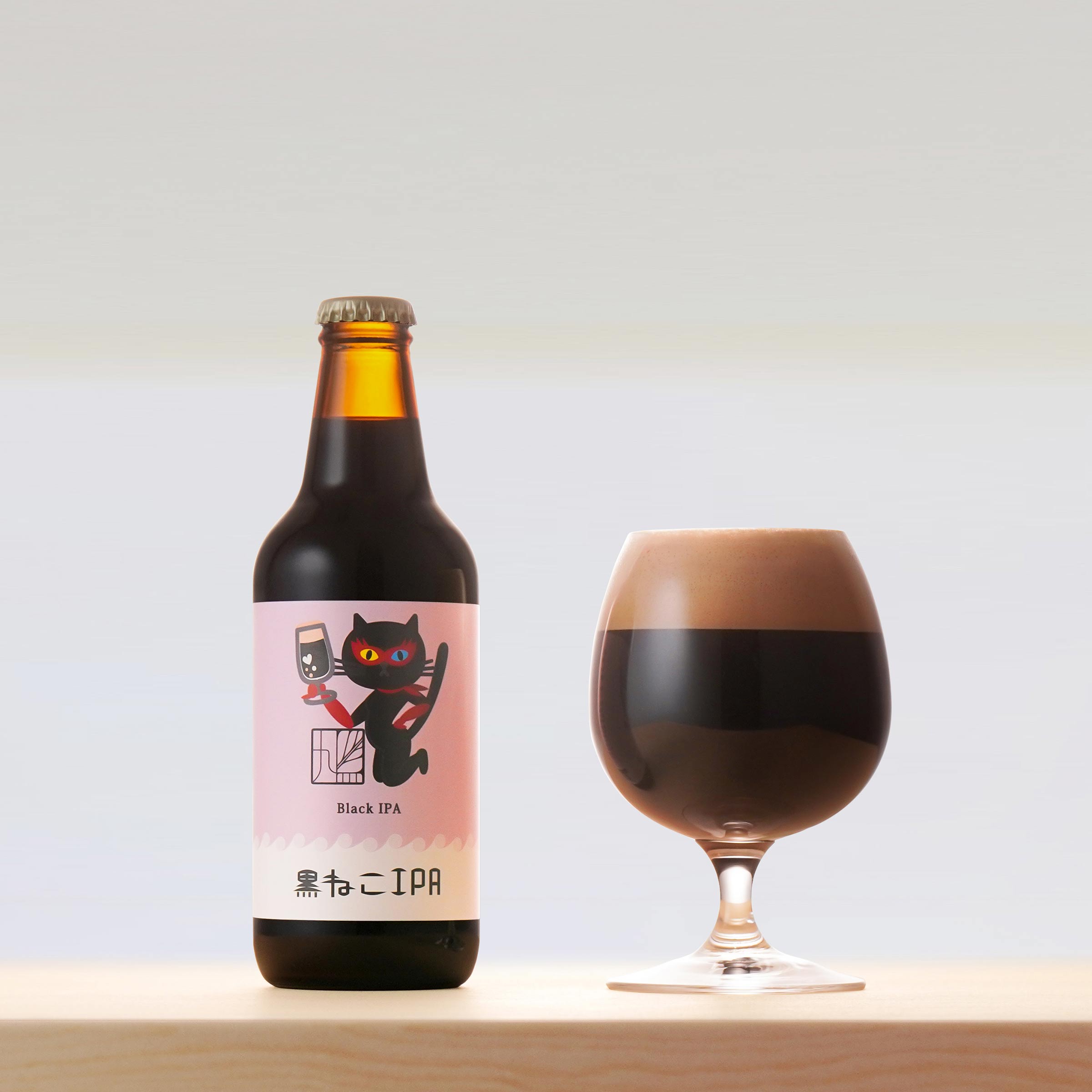 黒ねこIPAのビールボトルと、グラスに注いだビールの写真